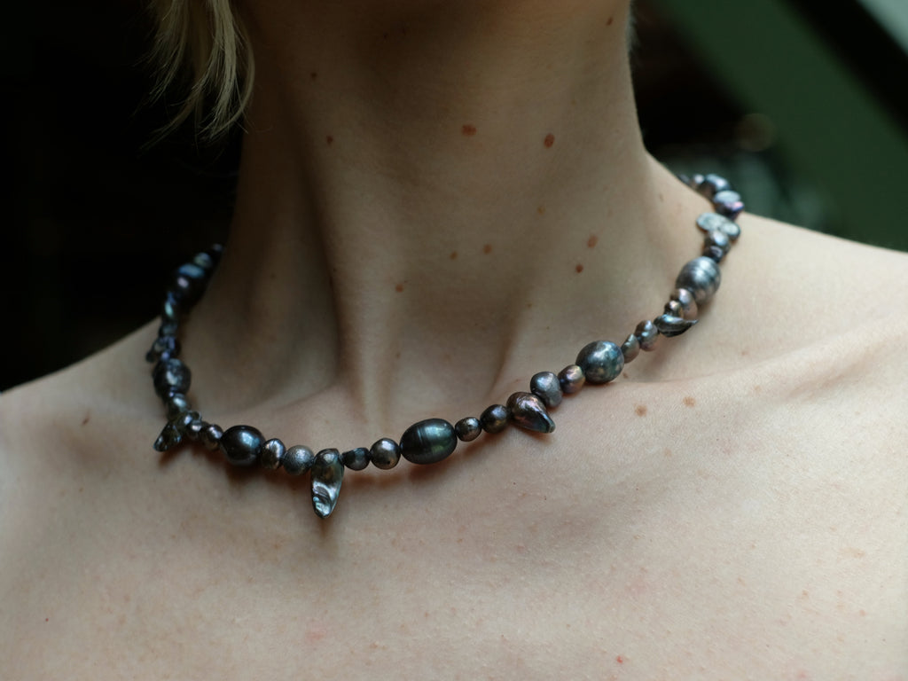 Perlenkette aus dunklen Barockperlen am Hals