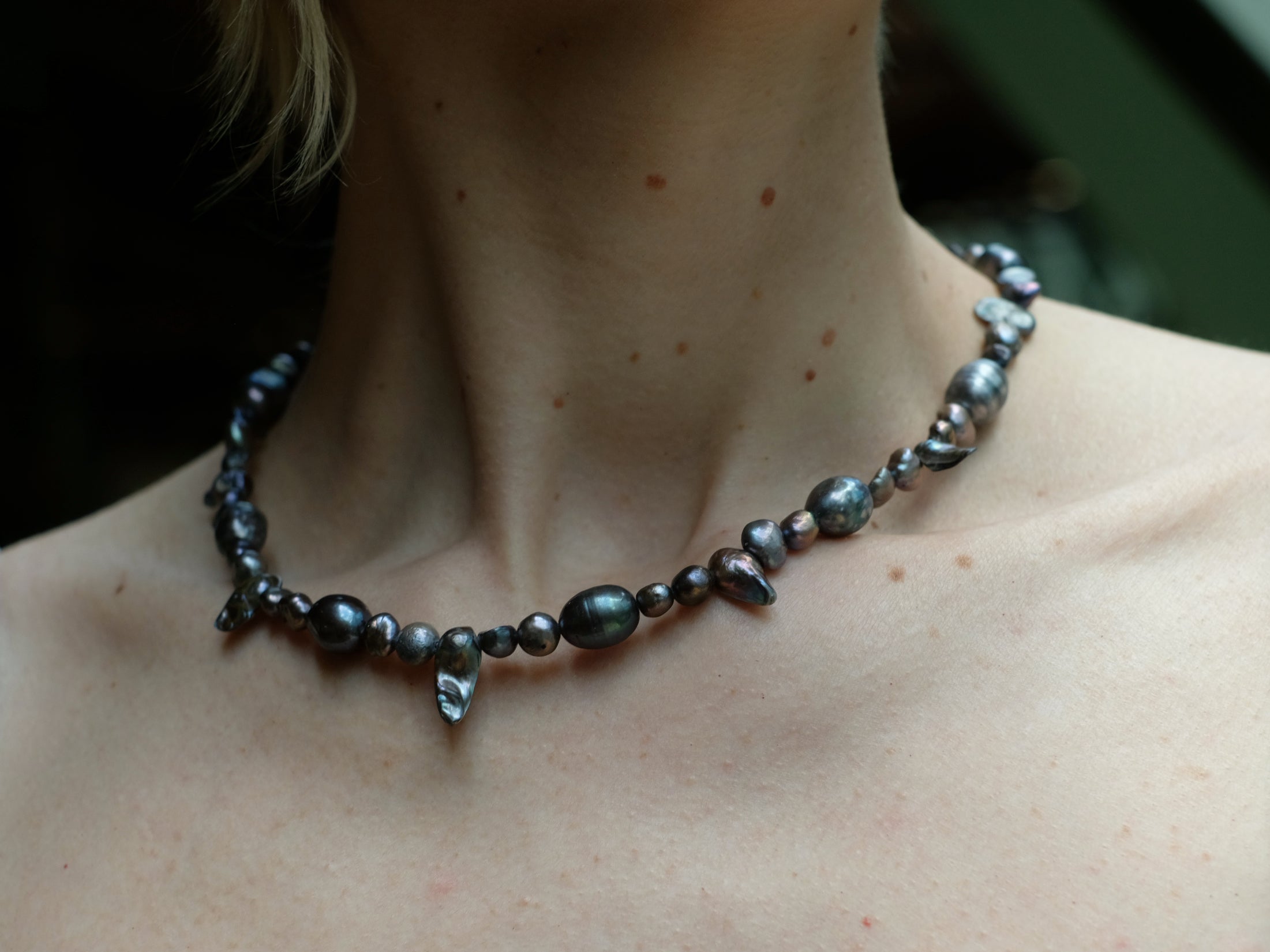 Perlenkette aus dunklen Barockperlen am Hals